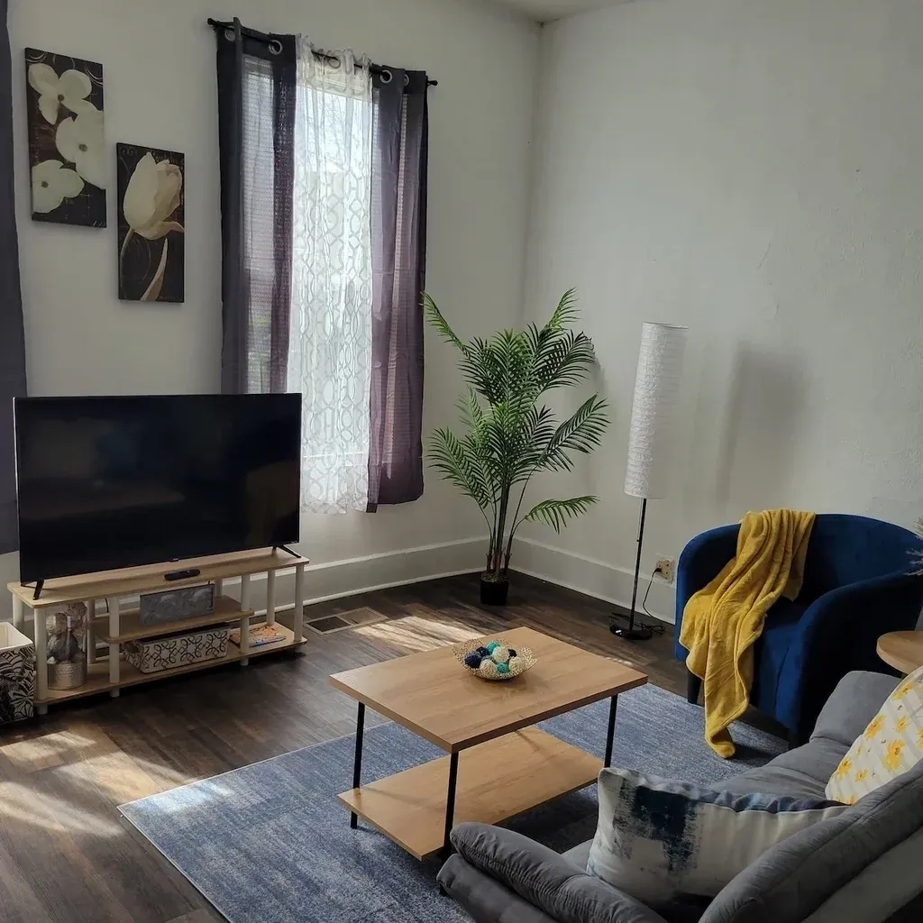 A living room with a couch, table and television.