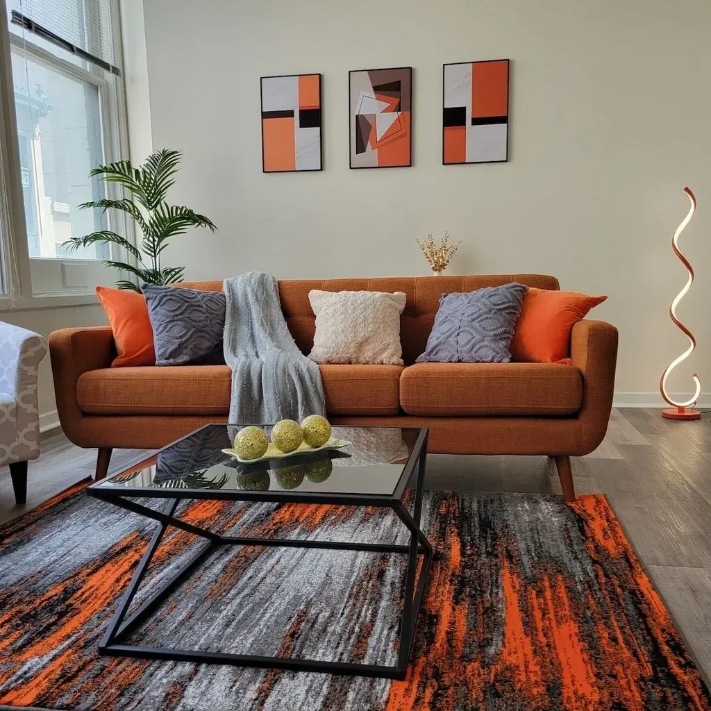 A living room with orange and grey decor